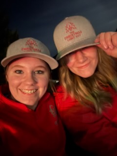 Two crew members in branded caps at a night install