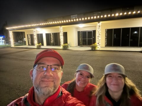The crew in front of a finished warm white commercial install at night